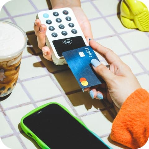 Un cliente paga con su teléfono en la terminal de un mostrador